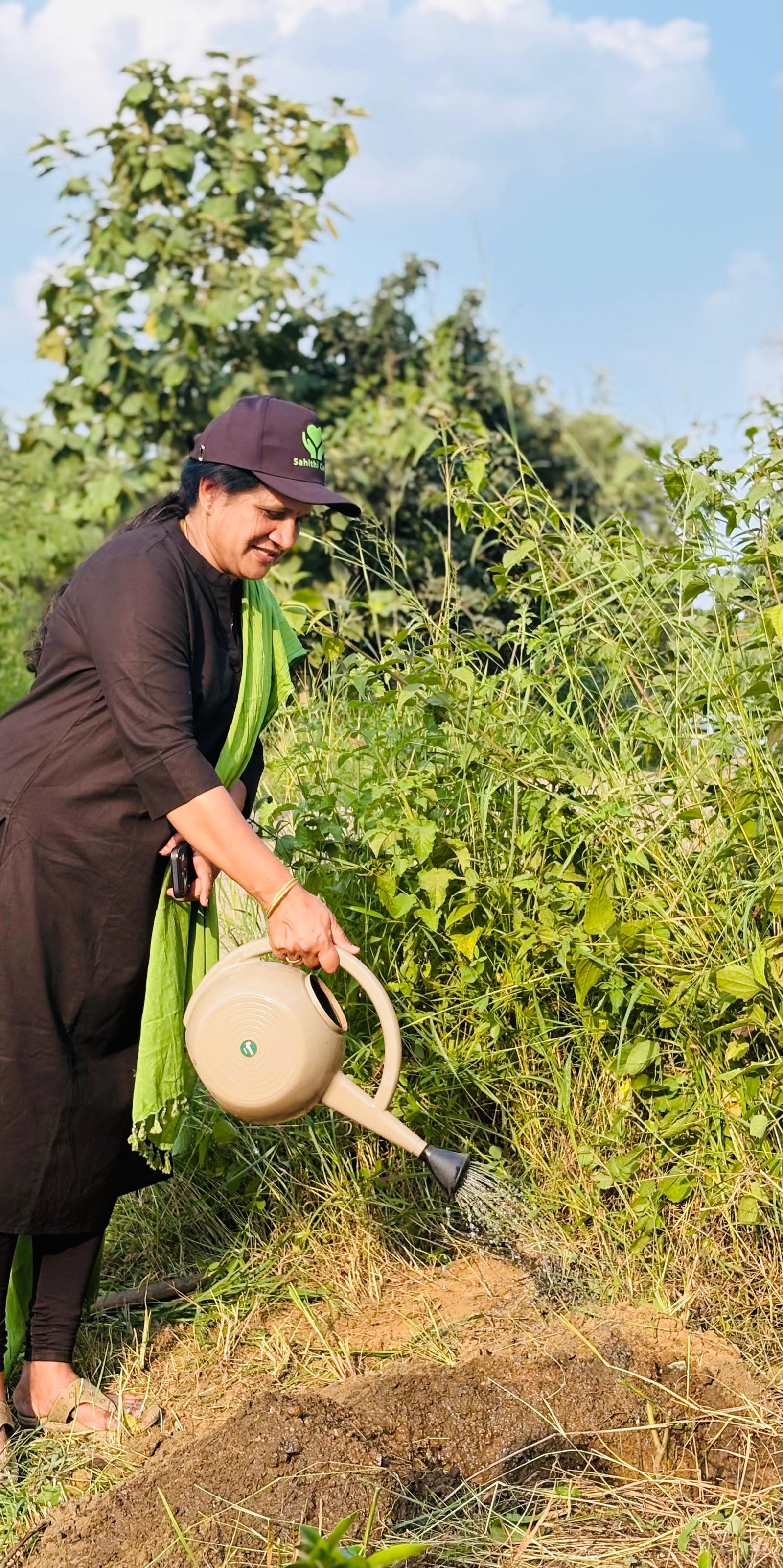 Sahithi Cares volunteer watering a newly planted tree